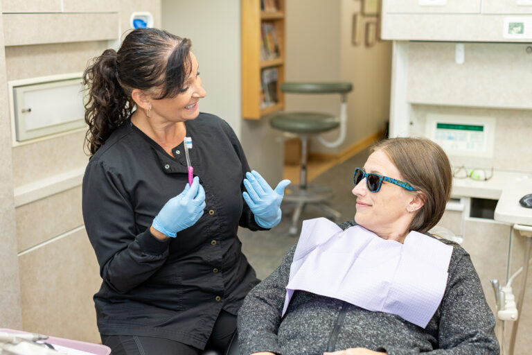 Rachel explaining how to properly brush teeth to a patient at Matlock Dental in Eugene, Oregon.