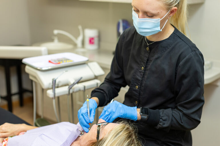 Mikayla cleaning a patients mouth at Matlock Dental in Eugene, Oregon.